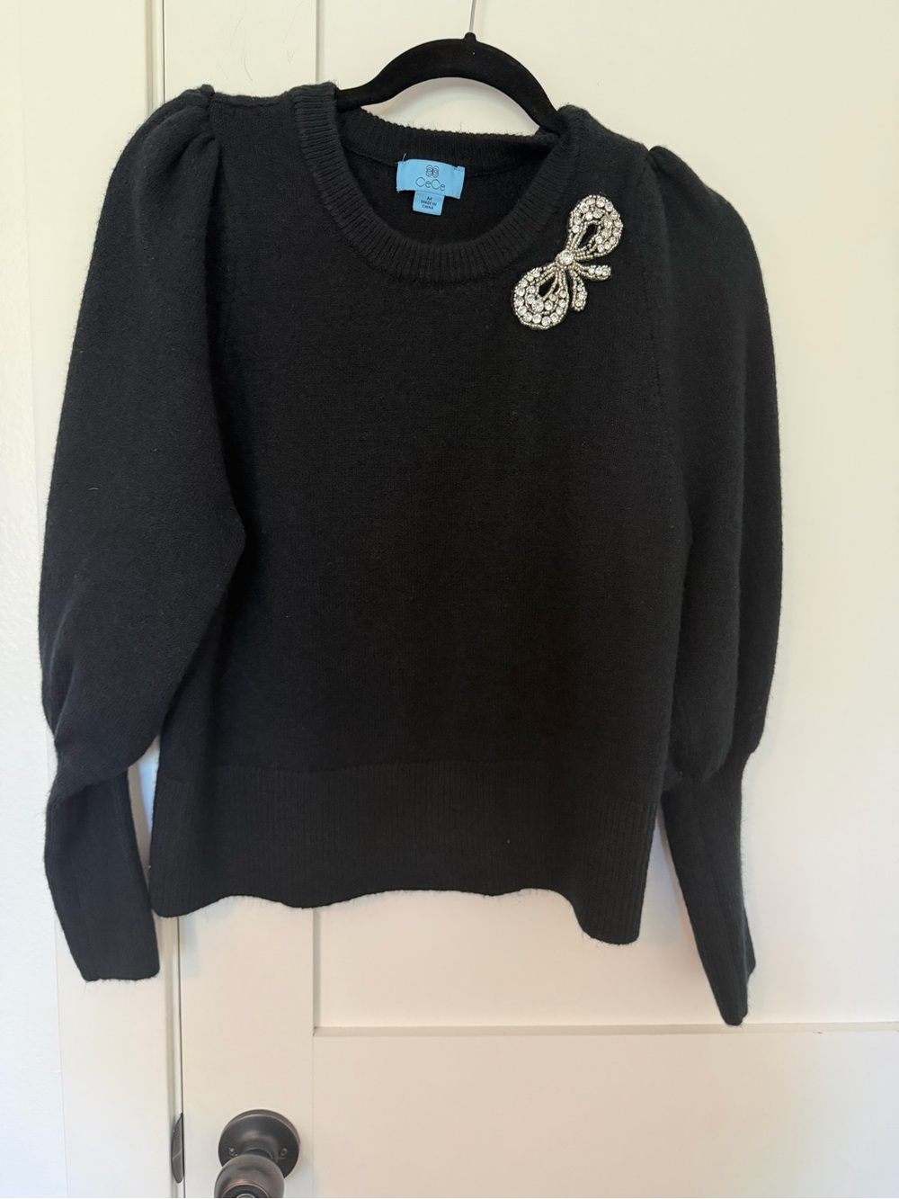 CeCe Black Puff-Sleeve Crewneck Sweater with Crystal Bow Brooch